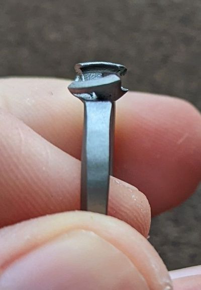 Close-up of the ring's claws held between two fingers, visibly not parallel to each other