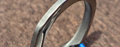Close-up of the finished ring's mirror-polished inner edge next to the matte, as-printed outer edge